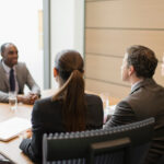 Business people interviewing businessman in conference room